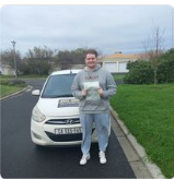 Learner standing beside a driving school car